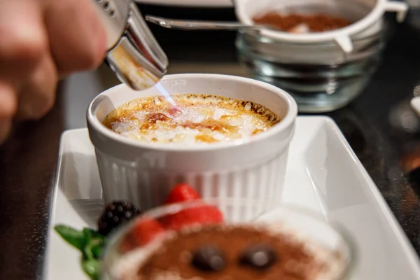 Krem karamelize edilmiş şeker, creme brulee popüler bir tatlıdır. Tabakları, tabakları ve mutfak sahnelerini gösterir.