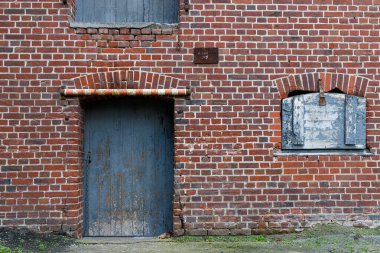 Doku görüntüsü, kırmızı ve yıpranmış tuğladan bir duvar mavi eski bir kapısı ve kapalı mavi ahşap bir penceresi var. Oyun varlıkları için doku referansı olarak kullan.