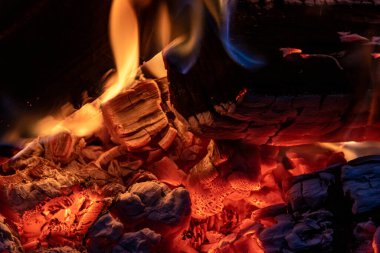 Küçük bir kamp ateşini yakın çekim bir yangın kasesinde parlayan közle, kış zamanı sıcaklık ve konfor üretir