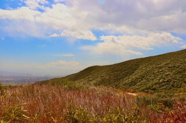 Güneşli bir günde dağların ve bulutların olduğu güzel yürüyüş patikası
