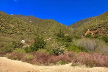 Güneşli bir günde dağların ve bulutların olduğu güzel yürüyüş patikası
