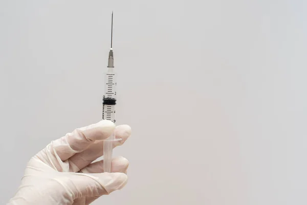 医学-手と白の背景を持つ注射器 — ストック写真