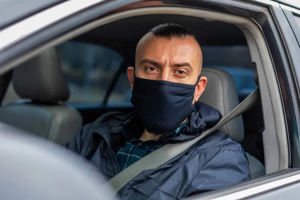 portrait of a driver in a medical black mask. looking at the camera. quarantine measures
