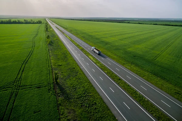 Ciężarówka Jazdy Asfaltowej Drodze Wzdłuż Zielonych Pól Widziany Powietrza Lotu — Zdjęcie stockowe