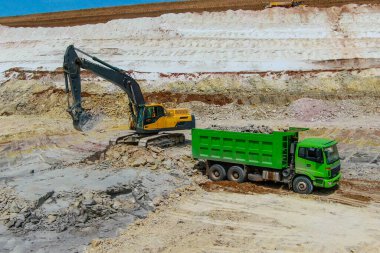 Kil madenciliği. Kazıcı mayınları mavi kil ve yeşil kamyona yükleniyor. 