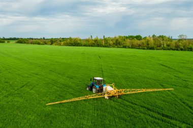 İlkbahar insansız hava aracı görünümünde yeşil alanda traktör spreyi gübresi, tarım geçmişi kavramı.
