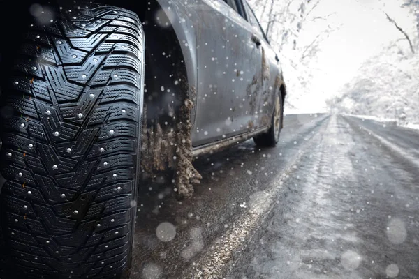 道路の雪に覆われた上で冬の車のスパイクタイヤの閉鎖 道路上の氷は — ストック写真