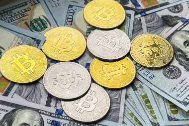100 dolarlık banknotlarda bir sürü altın ve gümüş Bitcoin var. Yakın plan.