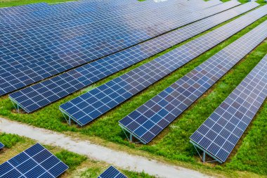 Temiz enerji üretimi için kullanılan bir güneş parkındaki güneş panelleri. Hava manzaralı. Drone fotoğrafı