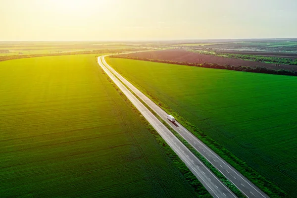 Vracht Levering Bij Zonsondergang Witte Vrachtwagen Rijden Asfaltweg Langs Groene — Stockfoto