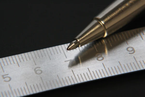 Üzerinde siyah bir adam yalan bir cetvel ile metal kalem