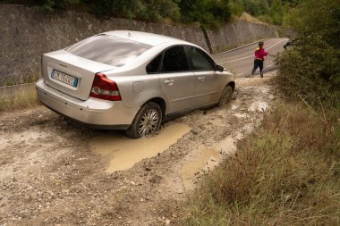 Abruzzo, İtalya - 18 Temmuz 2020, gümüş bir araba ve İtalya 'nın Abruzzo şehrinde çamura saplanmış biri.