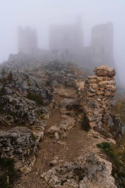 İtalya 'da Rocca Calascio, Abruzzo' daki ortaçağ şatosunun kalıntıları, sis ve bulutlar.