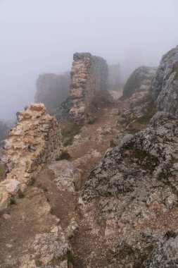 İtalya 'da Rocca Calascio, Abruzzo' daki ortaçağ şatosunun kalıntıları, sis ve bulutlar.