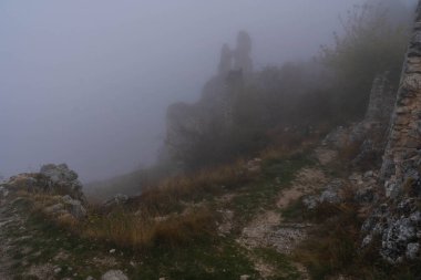 İtalya 'da Rocca Calasho, Abruzzo' daki ortaçağ şatosunun kalıntıları, sis ve bulutlar.