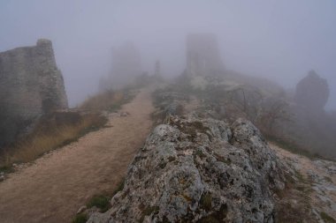 İtalya 'da Rocca Calasho, Abruzzo' daki ortaçağ şatosunun kalıntıları, sis ve bulutlar.