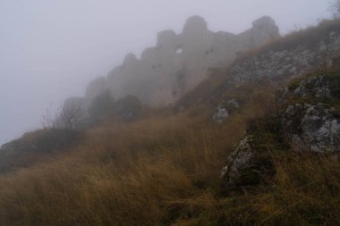 İtalya 'da Rocca Calasho, Abruzzo' daki ortaçağ şatosunun kalıntıları, sis ve bulutlar.