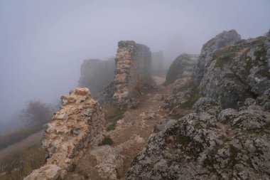 İtalya 'da Rocca Calasho, Abruzzo' daki ortaçağ şatosunun kalıntıları, sis ve bulutlar.