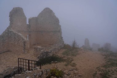 İtalya 'da Rocca Calasho, Abruzzo' daki ortaçağ şatosunun kalıntıları, sis ve bulutlar.