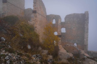 İtalya 'da Rocca Calasho, Abruzzo' daki ortaçağ şatosunun kalıntıları, sis ve bulutlar.