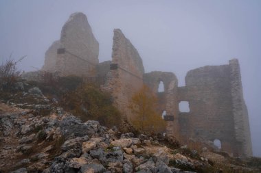 İtalya 'da Rocca Calasho, Abruzzo' daki ortaçağ şatosunun kalıntıları, sis ve bulutlar.