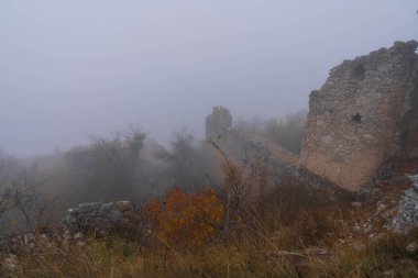 İtalya 'da Rocca Calasho, Abruzzo' daki ortaçağ şatosunun kalıntıları, sis ve bulutlar.