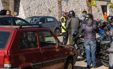 Orvinio, İtalya - 31 Ekim 2020, İtalyan Borgo Orvinio 'da ikinci koronavirüs dalgası (Covid19) sırasında durup yemek yiyen maskeli ve maskesi düşmüş motorcular,