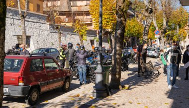 Orvinio, İtalya - 31 Ekim 2020, İtalyan Borgo Orvinio 'da ikinci koronavirüs dalgası (Covid19) sırasında durup yemek yiyen maskeli ve maskesi düşmüş motorcular,