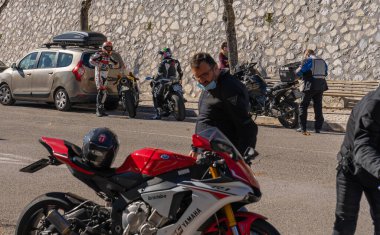 Orvinio, İtalya - 31 Ekim 2020, İtalyan Borgo Orvinio 'da ikinci koronavirüs dalgası (Covid19) sırasında durup yemek yiyen maskeli ve maskesi düşmüş motorcular,