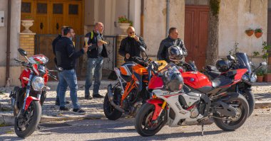 Orvinio, İtalya - 31 Ekim 2020, İtalyan Borgo Orvinio 'da ikinci koronavirüs dalgası (Covid19) sırasında durup yemek yiyen maskeli ve maskesi düşmüş motorcular,