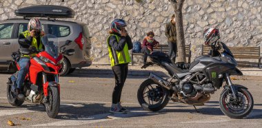 Orvinio, İtalya - 31 Ekim 2020, İtalyan Borgo Orvinio 'da ikinci koronavirüs dalgası (Covid19) sırasında durup yemek yiyen maskeli ve maskesi düşmüş motorcular,