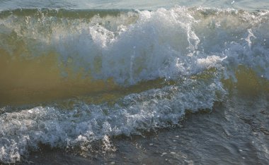 İtalya 'nın Sabaudia kentindeki Circeo parkındaki renkli deniz dalgaları ve beyaz dalgaların görüntüsünü kapat (seçici odak noktası)