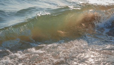 İtalya 'nın Sabaudia kentindeki Circeo parkındaki renkli deniz dalgaları ve beyaz dalgaların görüntüsünü kapat (seçici odak noktası)