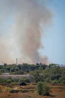 Roma, İtalya 'da gökyüzünde bir şehrin üzerindeki yangından çıkan dumanın görüntüsü