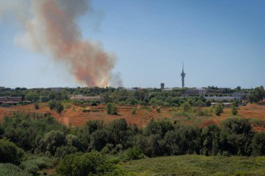Roma, İtalya 'da gökyüzünde bir şehrin üzerindeki yangından çıkan dumanın görüntüsü