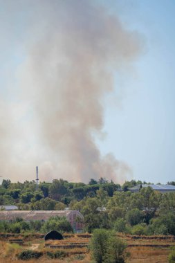 Roma, İtalya 'da gökyüzünde bir şehrin üzerindeki yangından çıkan dumanın görüntüsü