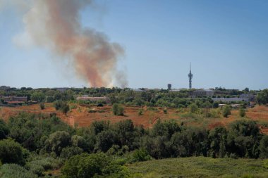 Roma, İtalya 'da gökyüzünde bir şehrin üzerindeki yangından çıkan dumanın görüntüsü