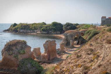 İtalya 'nın Torre Astura kentindeki kaleye giden bir ortaçağ kemer köprüsünün kalıntıları.