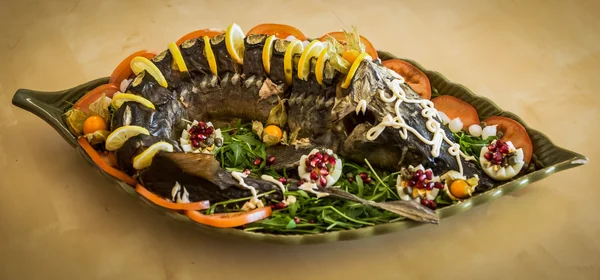 Limon ve domates ile dekore edilmiş mersin balığı