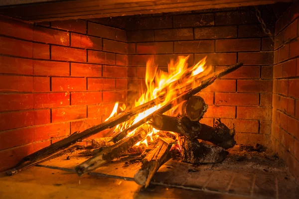 Feu brûlant dans une cheminée en brique rouge — Photo