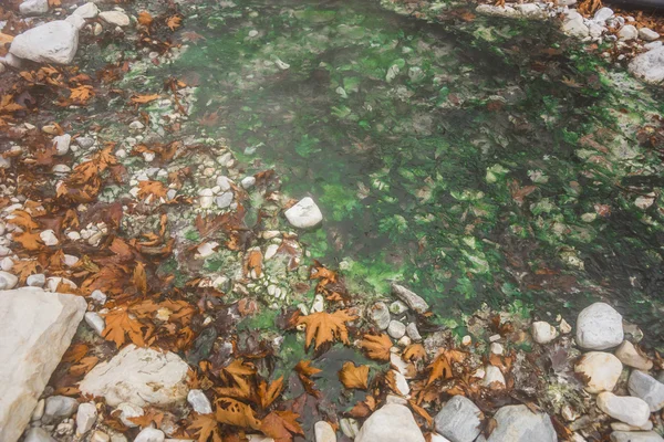 Fluss mit farbigen Steinen und heißen Quellen in loutra pozar, Norden — Stockfoto