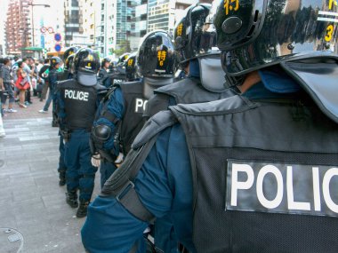 Tokyo, Japonya 'daki Yasukuni Tapınağı civarında çevik kuvvet polisleri var. Her 15 Ağustosta, sağ ve sol gruplar birbirlerine karşı dururlar.