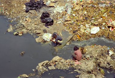 Katmandu, Nepal - 18 Nisan 1997: İki Nepalli beş para etmez bir nehirde satmak için bir şey arıyor. Nepal dünyanın en fakir ülkelerinden biriydi..