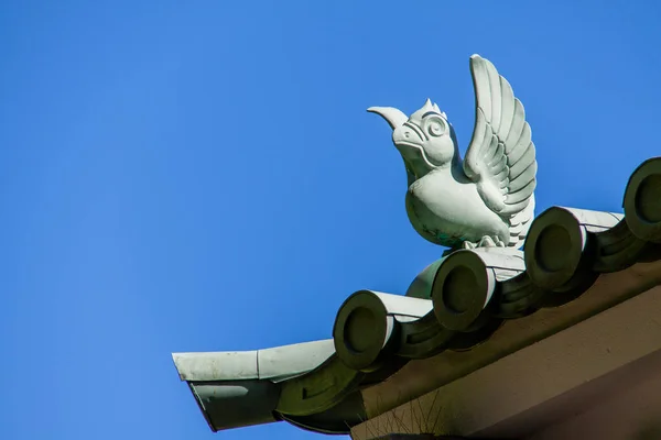 Bird-shaped Ornamental Tile set on tops a Shingled Roof
