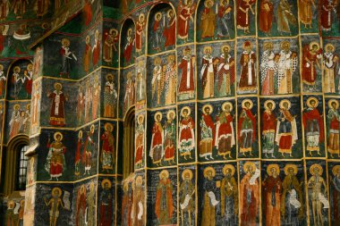 Romanya 'daki boyalı ortaçağ kilisesi. Sucevita Manastırı 'nın dış duvarında, çeşitli İncil sahneleri resmedilmiştir..