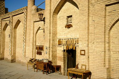 Özbekistan 'ın Khiva kentindeki geleneksel tuğla evin önünde satılan ahşap el sanatları