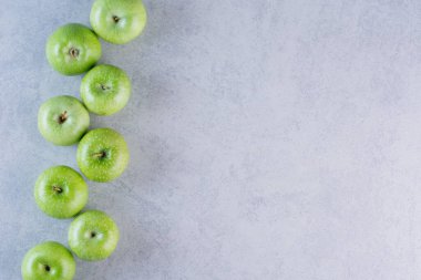 Gri arka planda yeşil elmalar. Üst Manzara. Boşluğu kopyala.