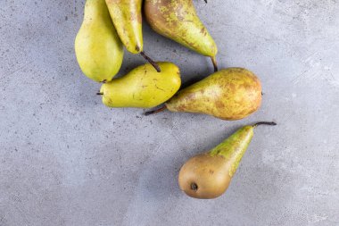 Gri arka planda taze olgun armutlar