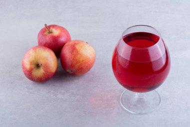 Gri arkaplanda taze elmalar olan soğuk elma suyu.