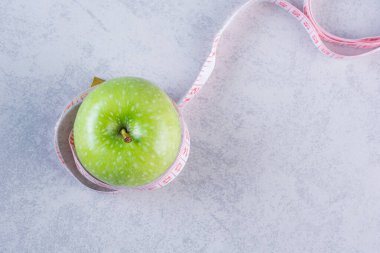 diyet konsepti beyaz arkaplanda elma ve mezura 